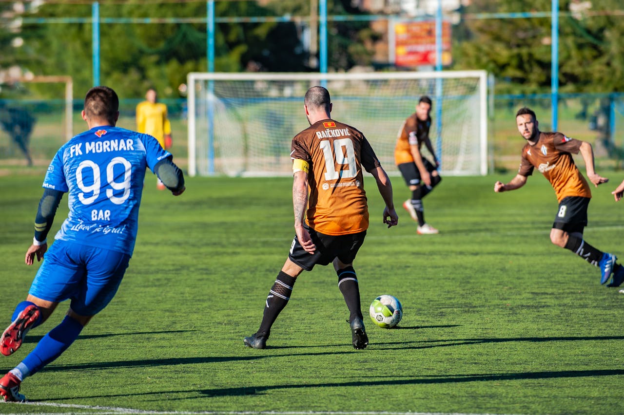 about-us Action-packed soccer match featuring players in team uniforms on a sunny day.
