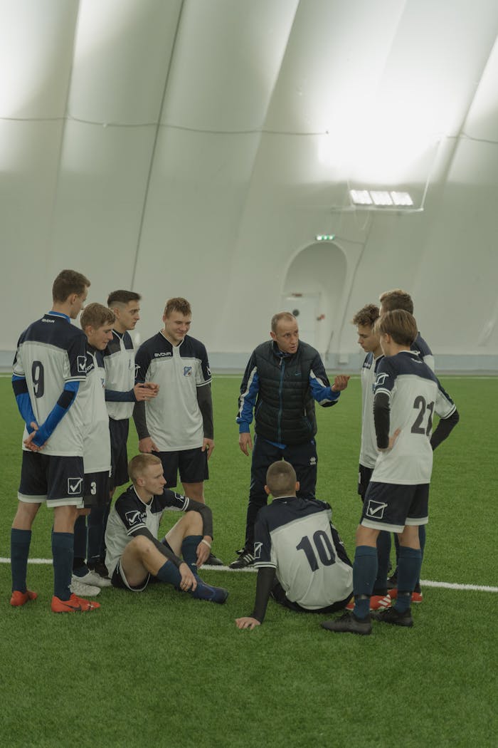 Mastering the First Impression: Your intriguing post title goes here Coach giving instructions to a young soccer team inside a sports facility.