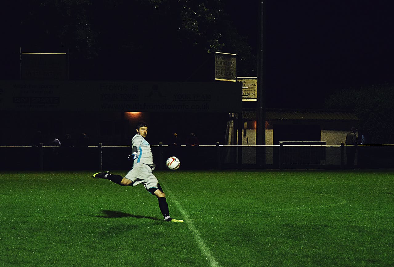 services-01 Dynamic action shot of a soccer player kicking the ball during a night game in Somerset, England.